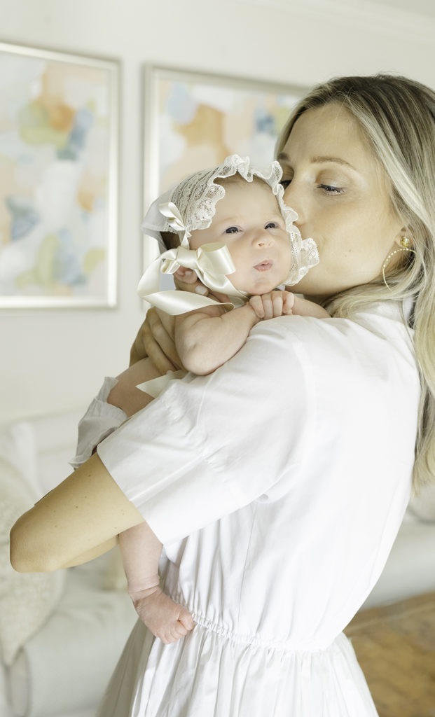 Mom kissing newborn baby wearing a bonnet by Birmingham Newborn Photographer
