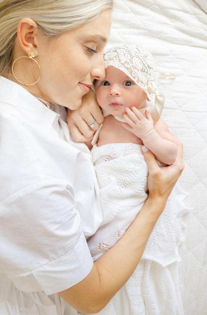 Mom and newborn baby lying on bed by Birmingham newborn photographer Whitney Carr Photography