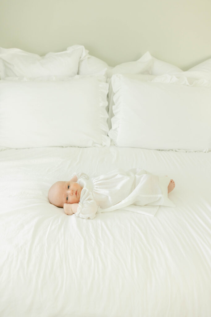 Newborn baby lying on bed awake by Birmingham Newborn Photographer