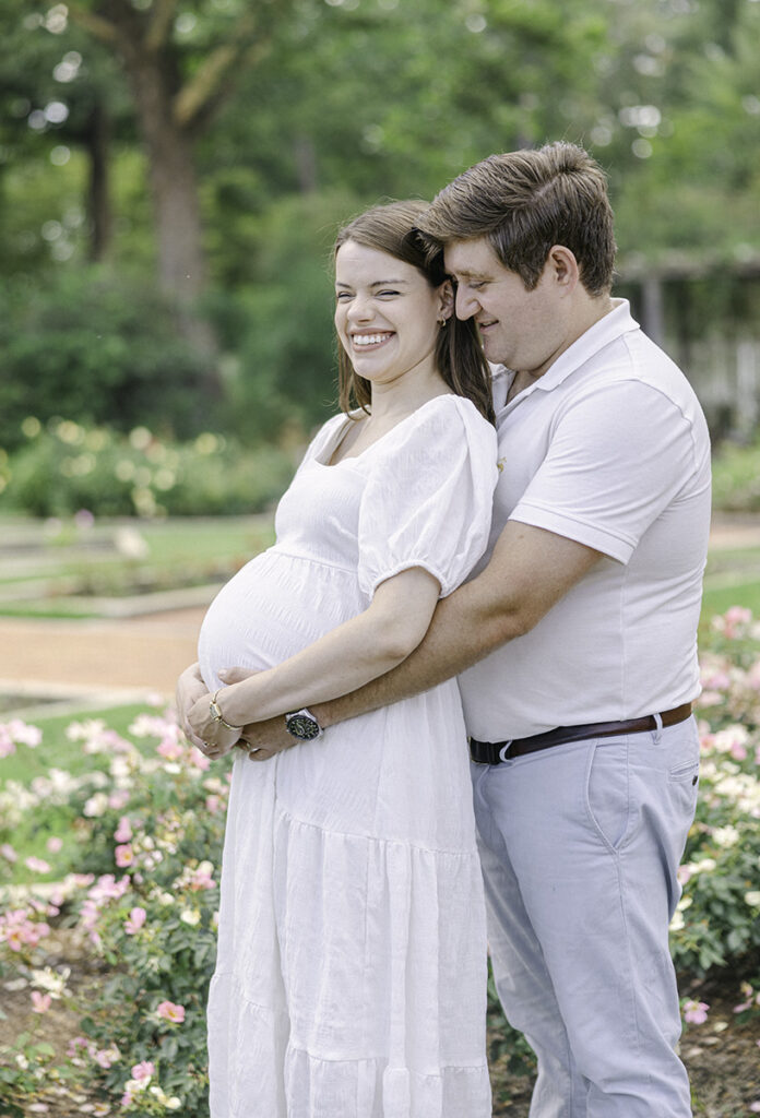 Pregnant mom and dad holding onto stomach while mom laughs by Birmingham Maternity Photographer 