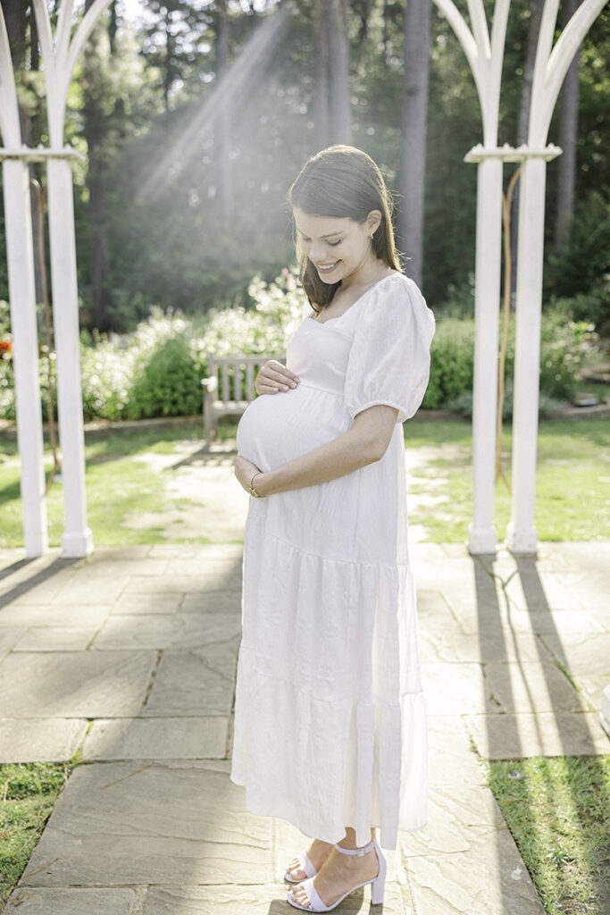 Pregnant mom holding and looking down at pregnant belly by Birmingham maternity photographer