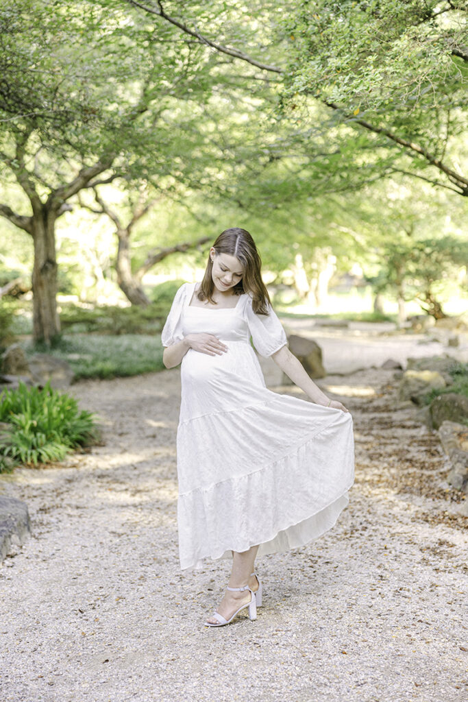 Mom holding dress and smiling down at her baby bump by Birmingham Maternity Photographer 
