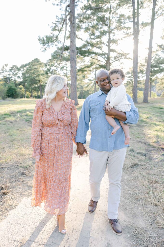 Family of 3 walking in a field by Birmingham Lifestyle Photographer - Whitney Carr Photography