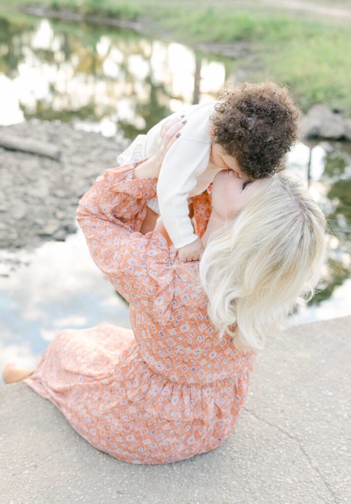 Mom lifting up toddler while he kisses her on the lips by Birmingham Lifestyle Photographer - Whitney Carr Photography