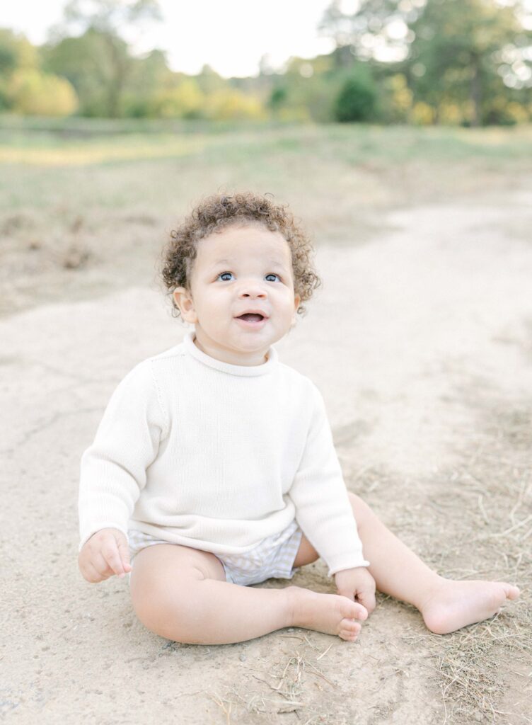 Toddler boy sitting on trail in a field by Birmingham Baby Photographer - Whitney Carr Photography