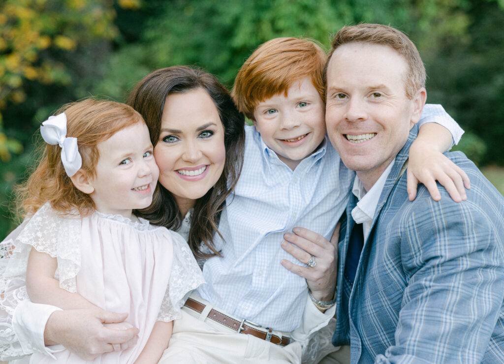 Family of 4 with 2 children smiling at the camera for fall family photos by Birmingham, AL family photographer