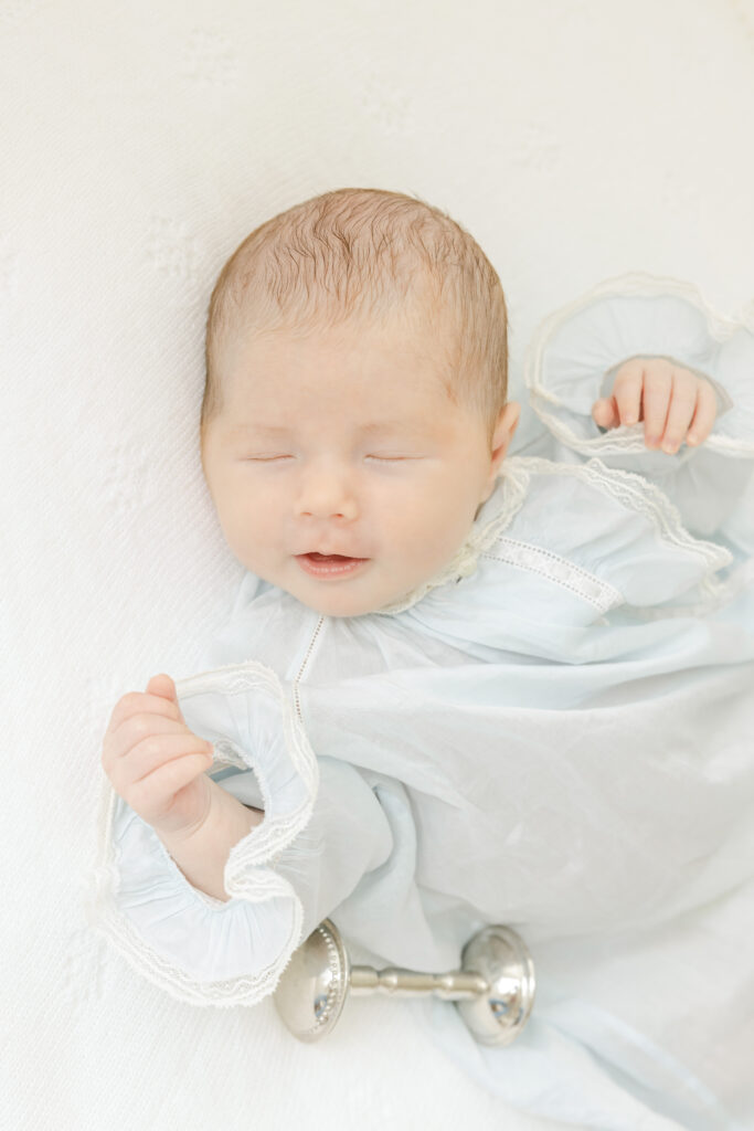 Newborn baby boy smiling next to family rattle in Birmingham lifestyle session