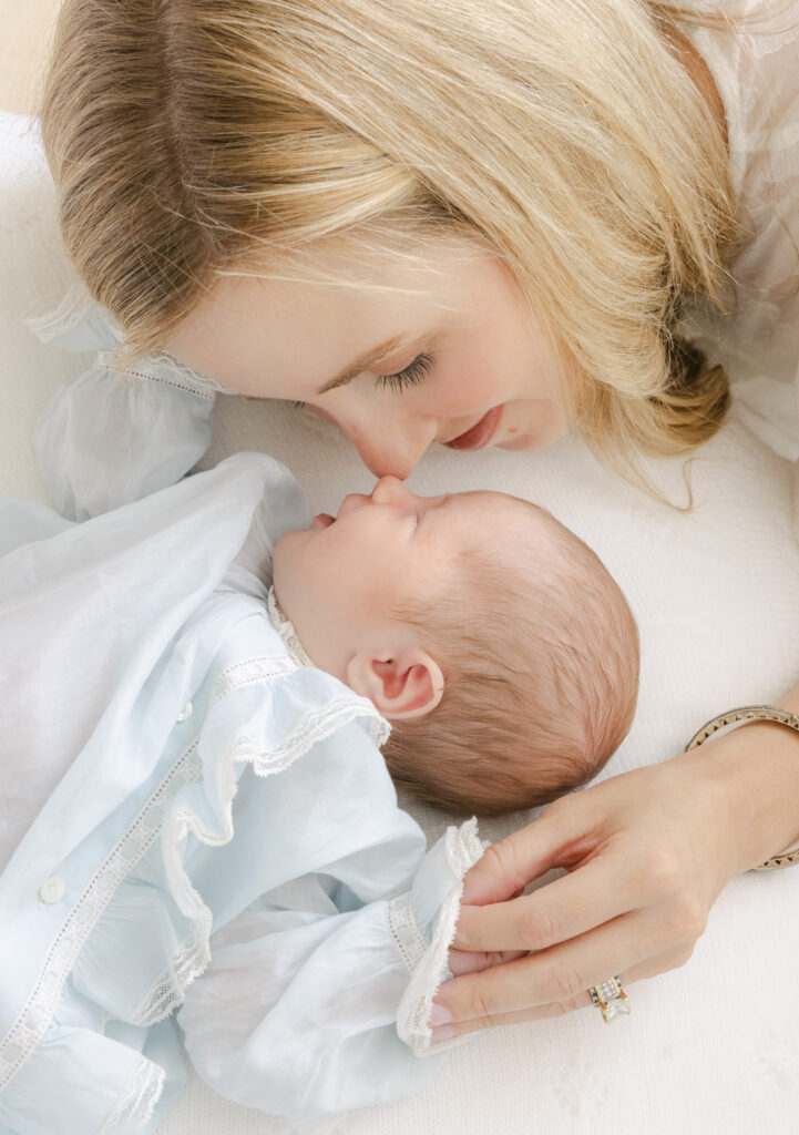 Mom and baby cuddling nose to nose on the day bed