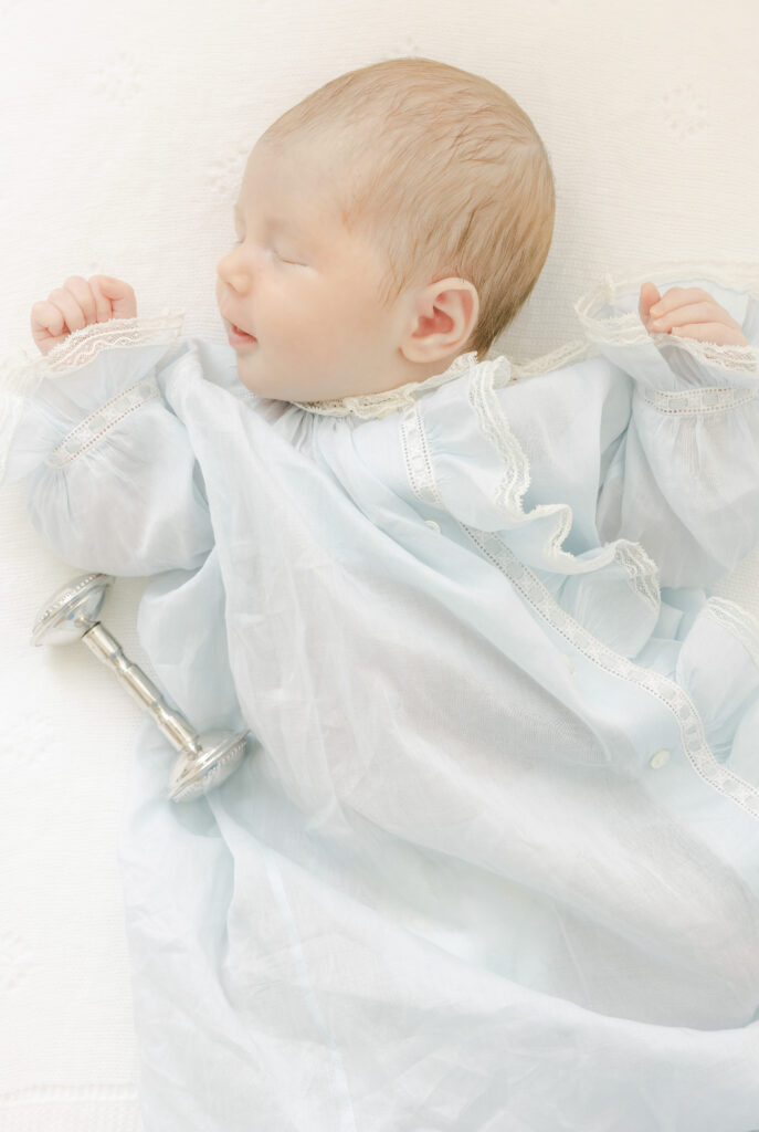 Newborn baby boy sleeping next to family rattle 