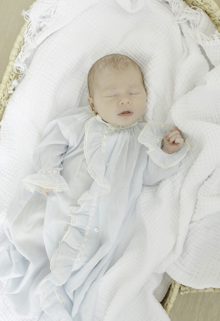 Baby boy sleeping in Moses basket